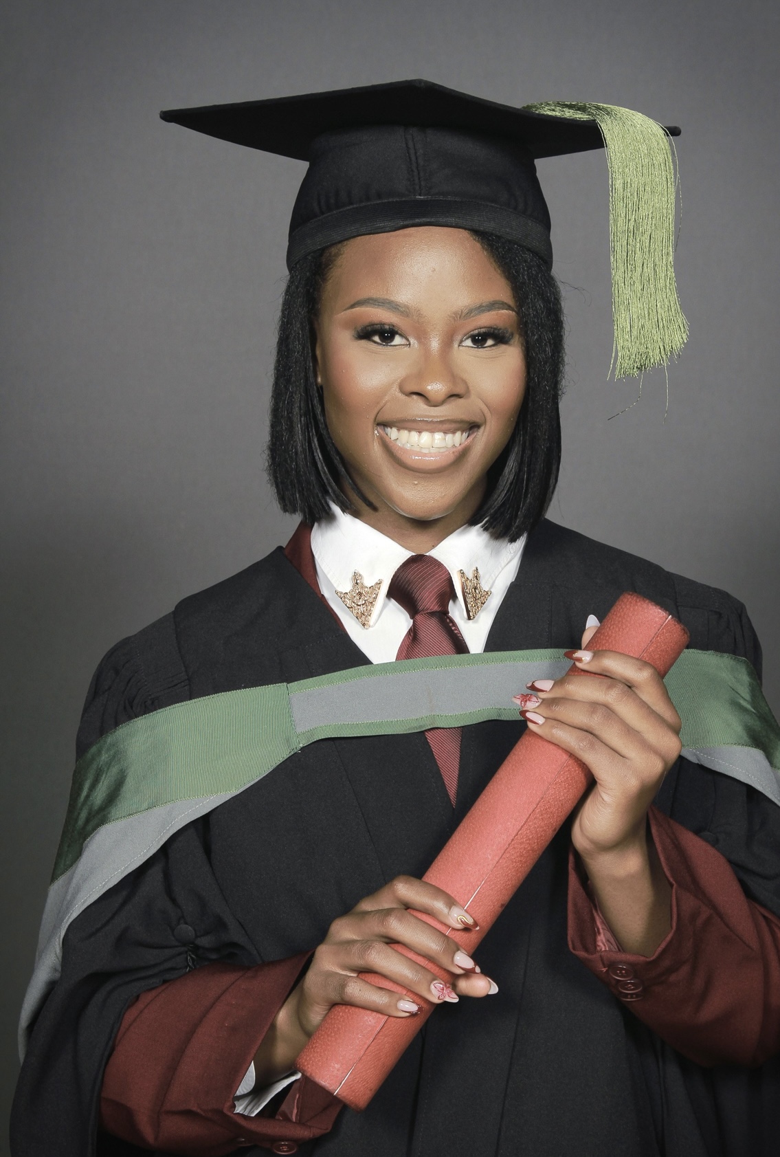 Lerato Mabalane graduation portrait in academic cap and gown holding a diploma